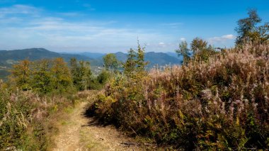 Mavi bulutlu gökyüzü ile dağ manzarası.