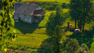 Yeşil çimlerin üzerinden bir manzara ve dağlarda küçük bir köy.