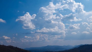 Dağları ve mavi gökyüzü olan güzel bir manzara.