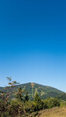 Dağları ve mavi gökyüzü olan güzel bir manzara.