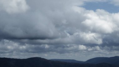 Bulutlu ve mavi gökyüzü olan dağ manzarası
