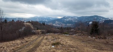 bulutlu gökyüzünde dağları olan güzel kış manzarası.