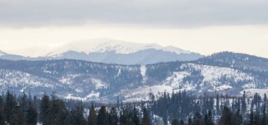 Karla kaplı dağ zirveleri ve sabahları bulutlar