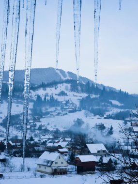 Arkasında bir ev olan karlı dağların güzel manzarası.