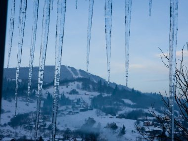 Bir dağın tepesinde sallanan buz sarkıtı