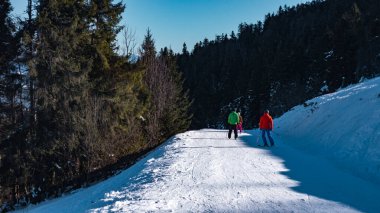 Bir adam ve bir kadın kar ormanında yürüyüş yapıyor. Güzel kar manzarası - tepeli dağ.