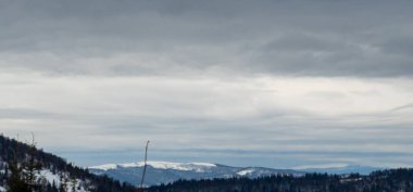 Kışın dağların üzerinde bulutlu bir gökyüzünün güzel bir görüntüsü.