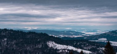 Karla kaplı güzel dağ manzarası - ön planda tepeli dağlar.