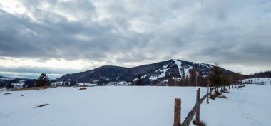 Kışlık dağ manzarası ve ahşap bir ev