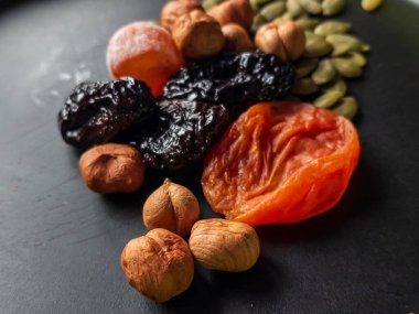 Siyah levhada kurutulmuş meyve karışımı.