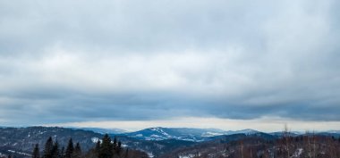 Kış manzarası karla kaplı - tepeli dağlar ve bulutlu gökyüzü. yüksek kaliteli fotoğraf