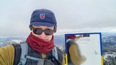 Turist bir dağın tepesinde fotoğraf çekiyor.