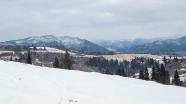 Dağlarda kış manzarası, karla kaplı tepeler.