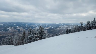 Kışın karla kaplı dağlarla kaplı güzel bir manzara..
