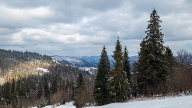 Karla kaplı bir dağ ve bulutlu bir gün ile kış manzarası