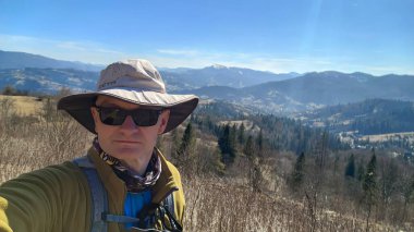 Sırt çantalı bir adam dağlarda yürüyüş yapıyor.