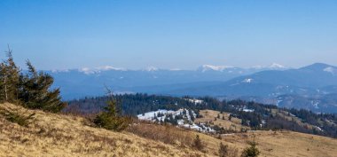 Dağları ve mavi gökyüzü olan güzel bir manzara.