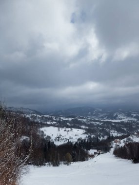 Bulutlu bir gökyüzü ile kış dağı manzarası