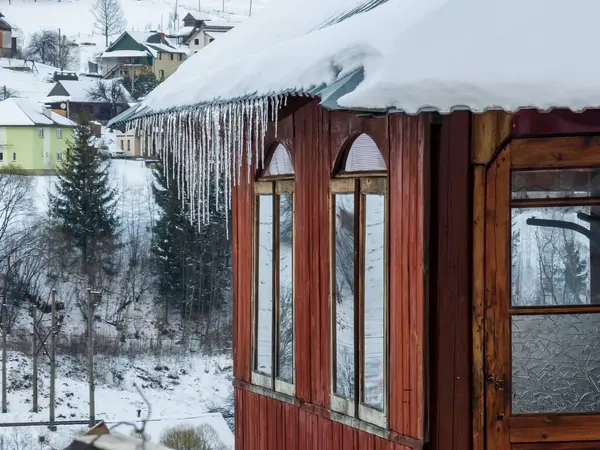 Ahşap bir kulübenin arka planında kar olan ahşap pencere.