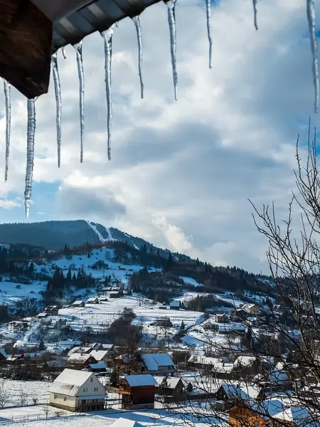 Beyaz karla kaplı tahta bir çitin dikey görüntüsü.