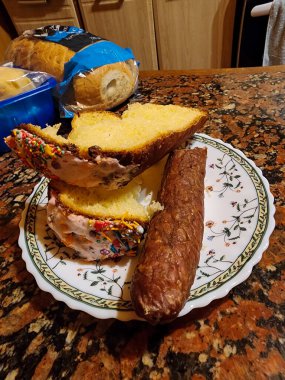 Tabakta bir parça ekmek ve masada bir tabak turta olan bir bıçak.