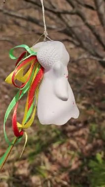 Yeşil yapraklı kırmızı fiyonklu beyaz şapkalı oyuncak bir kardan adam..