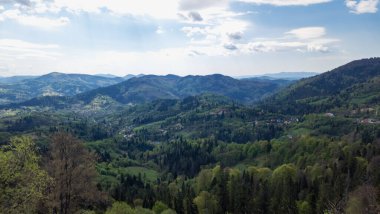 Ukrayna köyünün dağlarındaki tepenin tepesinden panoramik manzara. Dağlarda güneşli bir yaz günü. bu...