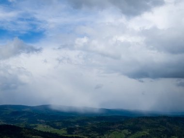 Bulutlar ve mavi gökyüzü dağların üzerinde