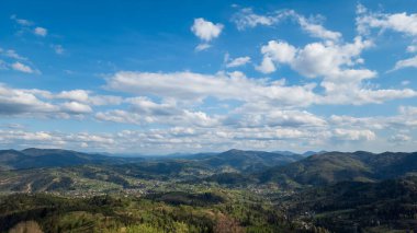 Güneşli bir günde Ukraynalı Karpatların köyü ve dağların manzarası.