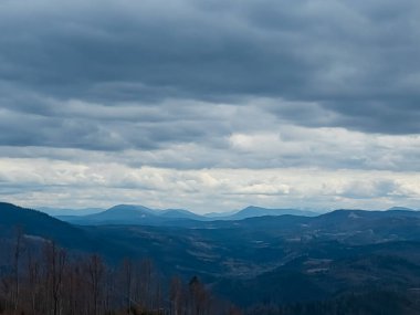 Bulutlu bir gökyüzünün altındaki dağ sırasının alçak açılı görüntüsü.