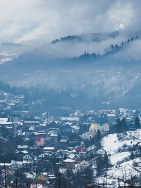 Dağlar ve ağaçlarla kaplı kış manzarası.