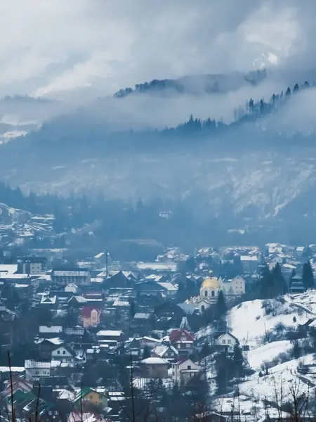 Dağlar ve ağaçlarla kaplı kış manzarası.