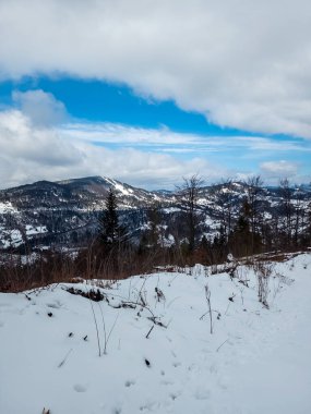Dağlarda kış manzarası, kar ve bulutlu bir gün.