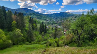 İspanya 'da bulutlu bir gökyüzünün altında yeşilliklerle çevrili güzel bir dağ manzarası.