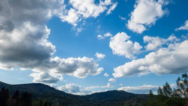 Arkasında bulutlar ve dağlar olan güzel bir manzara.
