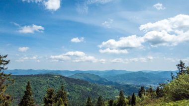 Dağları ve mavi gökyüzü olan güzel bir manzara.