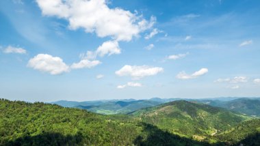 Bulutlu ve mavi gökyüzü olan dağ manzarası