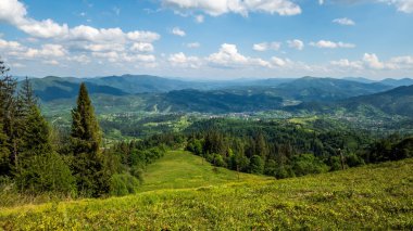 Yeşil ağaçları ve mavi gökyüzü olan güzel dağ manzarası