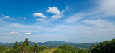 Dağları ve mavi gökyüzü olan güzel bir manzara.