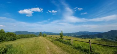 Dağları ve mavi gökyüzü olan güzel bir manzara.