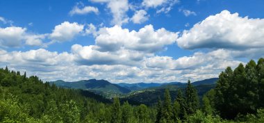 Bulutlu ve mavi gökyüzü olan dağ manzarası
