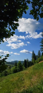 Dağları ve mavi gökyüzü olan güzel bir manzara.