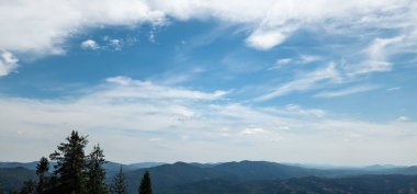 Dağları ve mavi gökyüzü olan güzel bir manzara.