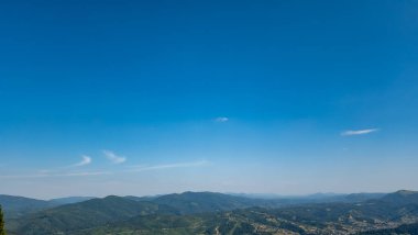 Dağları ve mavi gökyüzü olan güzel bir manzara.