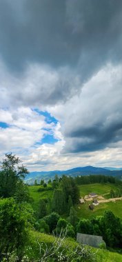 Dağları ve bulutlu gökyüzü olan güzel bir manzara.