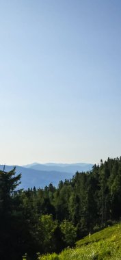 Dağları ve mavi gökyüzü olan güzel bir manzara.