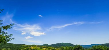 Dağları ve mavi gökyüzü olan güzel bir manzara.