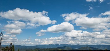 Bulutları ve mavi gökyüzü olan güzel bir manzara.
