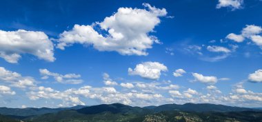 Dağları ve mavi gökyüzü olan güzel bir manzara.