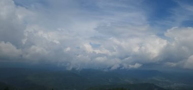 Dağları ve mavi gökyüzü olan güzel bir manzara.